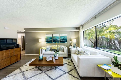 a living room with white furniture and a large window